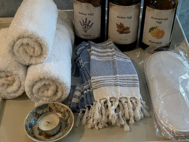 Rulo havlular, mavi peştemal ve aromaterapi yağları — Torium, Masaj Salonun